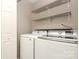 Convenient laundry room area with modern washer and dryer units and shelving at 7725 Petrea Ln, Charlotte, NC 28227
