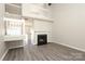 Bright living room with a fireplace, grey toned flooring, a high ceiling and a view of the staircase and entry to the kitchen at 7725 Petrea Ln, Charlotte, NC 28227