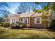 Inviting brick home featuring well-manicured landscaping and white shuttered windows at 924 S Main Ave, Newton, NC 28658