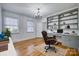 Bright home office featuring hardwood floors, custom built-in shelving, and an elegant chandelier at 924 S Main Ave, Newton, NC 28658