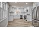 Modern kitchen with white cabinets, stainless steel appliances, and light wood floors at 924 S Main Ave, Newton, NC 28658