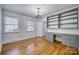 Home office featuring hardwood floors, custom built-in shelving, and a stylish chandelier at 924 S Main Ave, Newton, NC 28658