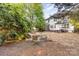 A backyard featuring a stone fire pit and outdoor seating surrounded by lush greenery at 10230 Blackstock Rd, Huntersville, NC 28078