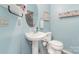 Cozy powder room features pedestal sink, wainscoting, & decorative shelving for a touch of charm at 10230 Blackstock Rd, Huntersville, NC 28078