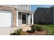 Inviting front entrance with a dark wooden door, brick accents, and manicured landscaping at 1109 Foxberry Ln, Maiden, NC 28650