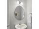 Stylish bathroom featuring a pedestal sink, modern faucet, and oval mirror at 11206 Grenfell Ave, Huntersville, NC 28078