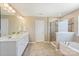 Bathroom featuring double vanity sinks, soaking tub, and tiled shower at 11206 Grenfell Ave, Huntersville, NC 28078
