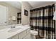 Well-lit bathroom featuring a shower with stylish curtain, toilet, and vanity with large mirror at 11206 Grenfell Ave, Huntersville, NC 28078