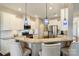 Stylish kitchen featuring granite countertops, stainless steel appliances, white cabinetry, and island seating with blue pendant lights at 11206 Grenfell Ave, Huntersville, NC 28078