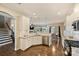 Open kitchen and living area with white cabinets, granite countertops, stainless appliances, hardwood floors, and stairs to upper level at 11206 Grenfell Ave, Huntersville, NC 28078