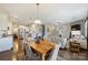 Open living area with hardwood floors, modern furnishings, staircase, and kitchen with granite countertops and stainless steel appliances at 11206 Grenfell Ave, Huntersville, NC 28078