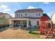 Back of house showcasing a covered outdoor patio with fire pit and a playset at 12018 Grey Partridge Dr, Charlotte, NC 28278