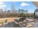 Landscaped backyard with stone patio, lounge chairs and a view of the wooded perimeter at 12018 Grey Partridge Dr, Charlotte, NC 28278