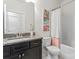 Well-lit bathroom features a dark vanity with granite countertop and shower with white tile and a shower curtain at 12018 Grey Partridge Dr, Charlotte, NC 28278