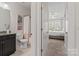 Well-lit bathroom features a dark vanity with granite countertop, shower with white tile and a shower curtain at 12018 Grey Partridge Dr, Charlotte, NC 28278