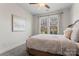 Bright bedroom with neutral carpet, ceiling fan, and large window overlooking the front yard at 12018 Grey Partridge Dr, Charlotte, NC 28278