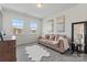 Bright bonus room with carpet, two windows, and a tan couch with decorative pillows and blanket at 12018 Grey Partridge Dr, Charlotte, NC 28278