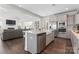 Open concept kitchen with a gray island, seamlessly connected to the living areas with fireplace at 12018 Grey Partridge Dr, Charlotte, NC 28278
