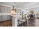 Well-lit kitchen featuring gray cabinets, an island with seating, and stainless steel appliances at 12018 Grey Partridge Dr, Charlotte, NC 28278