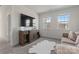 Bright living room with a large TV mounted above a wooden cabinet with open shelving and a stylish white rug at 12018 Grey Partridge Dr, Charlotte, NC 28278