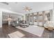 The living room with dark wood floors, a ceiling fan, lots of windows, and view to kitchen at 12018 Grey Partridge Dr, Charlotte, NC 28278