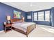 Cozy bedroom featuring dark blue walls, ample natural light, and comfortable furnishings at 1244 Madison Towns Ln, Charlotte, NC 28209