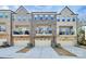 Attractive townhome exterior featuring a brick facade, private balconies, and attached garages at 1244 Madison Towns Ln, Charlotte, NC 28209
