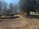 Unkept backyard with outbuildings and overgrown landscaping, a blank canvas to create your dream oasis at 128 Trexler Ave, Mount Holly, NC 28120
