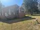 Cozy brick home exterior with mature trees and a partially overgrown yard offering privacy at 128 Trexler Ave, Mount Holly, NC 28120