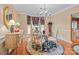 A formal dining room featuring a glass table, decorative rug, elegant chandelier, and natural lighting at 13132 Purple Dawn Dr, Charlotte, NC 28213