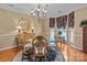 A bright dining room showcases a glass-top table, wood chairs, decorative rug, and large windows at 13132 Purple Dawn Dr, Charlotte, NC 28213