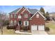 Charming two-story brick home featuring an attached two car garage and manicured landscaping at 13132 Purple Dawn Dr, Charlotte, NC 28213
