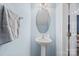 Cozy powder room featuring a pedestal sink, an oval mirror, and light blue walls at 157 Talbert Town Loop, Mooresville, NC 28117