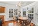 Bright breakfast nook featuring a round wooden table, four chairs, hardwood floors, and three large windows at 157 Talbert Town Loop, Mooresville, NC 28117