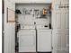 A bright laundry area featuring a white washer and dryer, a shelf, and a message board at 157 Talbert Town Loop, Mooresville, NC 28117