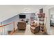 This loft features neutral walls, natural light, and is furnished with comfortable seating and decor at 157 Talbert Town Loop, Mooresville, NC 28117