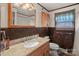 Cozy bathroom with wood paneling, a window, and a framed mirror above the granite sink at 1874 Mcilwain Rd, Lancaster, SC 29720