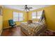 Cozy bedroom featuring two windows, a ceiling fan, and plaid bedding at 1874 Mcilwain Rd, Lancaster, SC 29720
