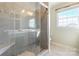 Elegant bathroom featuring a tiled shower with glass door, a window, and neutral tile flooring at 1910 Connemara Ct, Gastonia, NC 28054