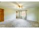 Light-filled bedroom featuring neutral carpet, a ceiling fan, and a window with floral curtains at 1910 Connemara Ct, Gastonia, NC 28054