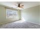 Inviting bedroom with large window, neutral carpet, ceiling fan, and soft green walls at 1910 Connemara Ct, Gastonia, NC 28054