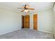 Comfortable bedroom featuring neutral carpet, ceiling fan, soft green walls, and wood-grain doors at 1910 Connemara Ct, Gastonia, NC 28054