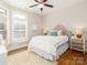 Bright bedroom featuring a plush bed, hardwood floors, and a large window at 2209 Lincolnshire Ln, Waxhaw, NC 28173