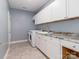 Convenient laundry room featuring white cabinets, a sink, and modern washer and dryer at 2209 Lincolnshire Ln, Waxhaw, NC 28173