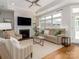 Bright living room with a fireplace, large windows, hardwood floors, and stylish neutral-toned furniture at 2209 Lincolnshire Ln, Waxhaw, NC 28173