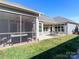 View of the screened patio, outdoor patio with table and chairs, and well-manicured backyard at 2209 Lincolnshire Ln, Waxhaw, NC 28173