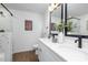 Modern bathroom featuring double sinks, white countertops, and dark, sleek fixtures, with tiled shower at 222 Ventner Ct, Charlotte, NC 28214