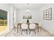 Elegant dining room with a wooden table, six chairs, modern lighting, and a sliding glass door at 222 Ventner Ct, Charlotte, NC 28214