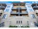 Eye-level view of the condo building's facade with balconies, brick accents, and meticulously maintained landscaping at 2401 Euclid Ave # 306, Charlotte, NC 28203
