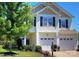 Charming two-story home with a well-manicured lawn, mature tree, and two-car garage at 249 Sand Paver Way, Fort Mill, SC 29708